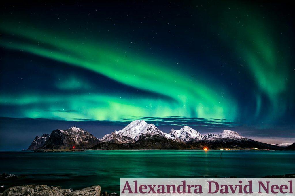 Breathtaking view of aurora borealis illuminating the snowy mountains of Lofoten Islands at night.