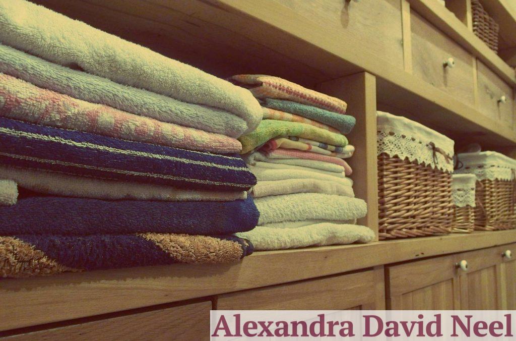 Tidy wooden cabinet with neatly stacked towels and decorative baskets in an indoor setting.